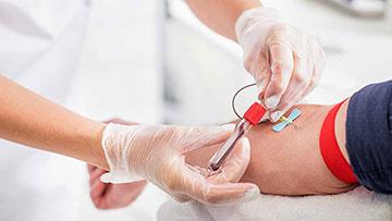 Person having blood drawn from arm.